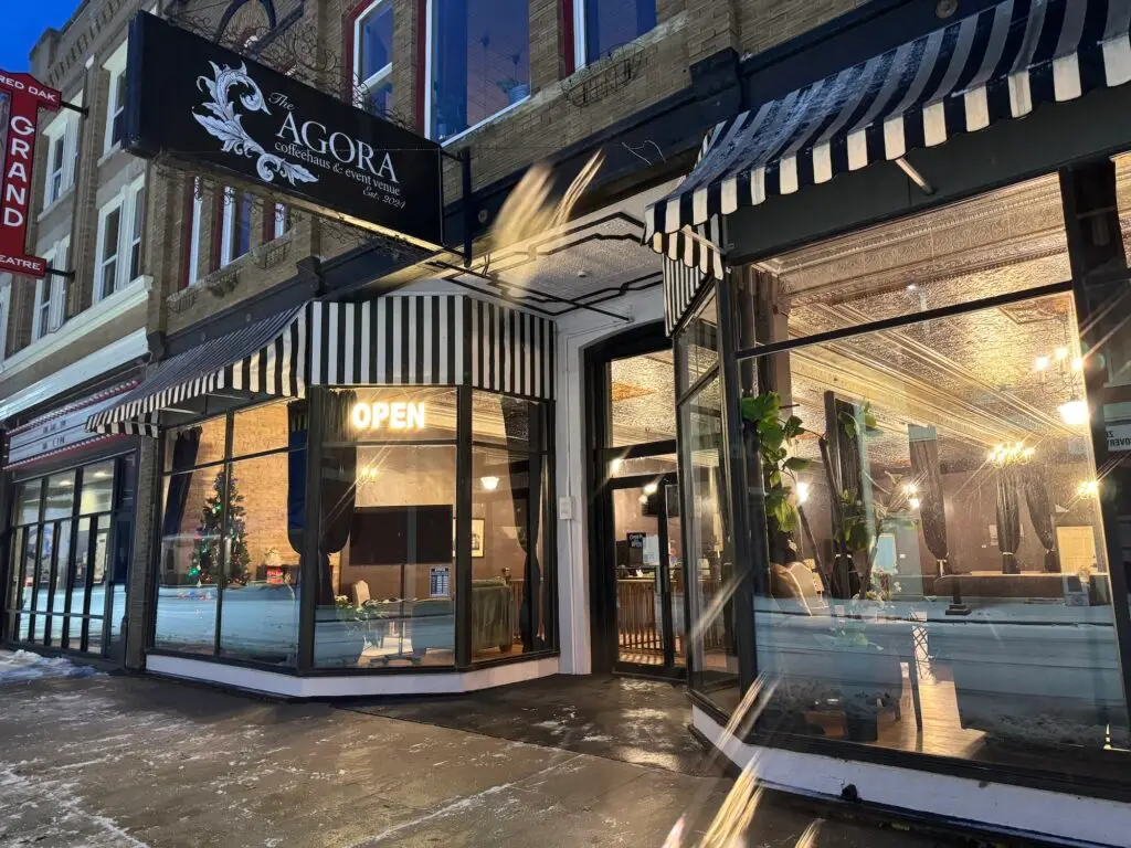 The exterior of the Agora Coffeehaus on the opening day. Warm light peers through the windows of a cold Saturday morning with light dusting of snow on the ground.